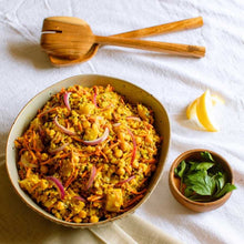 Load image into Gallery viewer, Colorful salad in a bowl with wooden utensils and lemon slices on a white cloth.