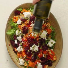Load image into Gallery viewer, Salad with beets, carrots, and goat cheese being drizzled with olive oil.