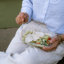 Load image into Gallery viewer, Person holding a creamy pesto chicken pasta in a takeaway container.
