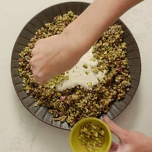 Load image into Gallery viewer, Grain salad on grey bowl with hand garnishing