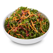 Load image into Gallery viewer, A bowl of kale and quinoa salad with tahini dressing, garnished with seeds and spices.