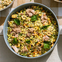 Load image into Gallery viewer, Bowl of salad with tuna, olives, and greens on a checkered tablecloth