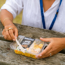 Load image into Gallery viewer, Person opening a container of food on a wooden surface