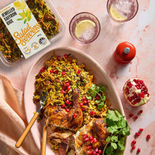 Load image into Gallery viewer, A serving tray and plastic tub of jewelled saffron rice. Grilled chicken on top of the tray of saffron rice and a pomegranate and glasses of lemonade on the side