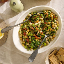 Load image into Gallery viewer, Mediterranean Chickpea salad in a white bowl with two serving spoons
