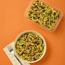 Load image into Gallery viewer, A white bowl and plastic tub of Jewelled Saffron Rice on an orange background.