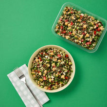 Load image into Gallery viewer, A cream bowl and plastic tub of Lentil Tabbouleh on a green background.