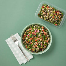 Load image into Gallery viewer,  green bowl and plastic container of Quinoa Tabbouleh on a forest green background.