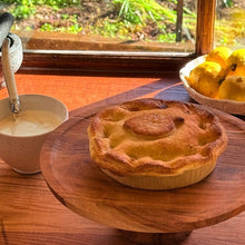 Load image into Gallery viewer, Pie on a wooden board with a cup of cream and fruit in the background