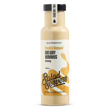Load image into Gallery viewer, A bottle of Salad Servers freshly dressed creamy hummus dressing, featuring a white label with yellow-orange graphic splashes and a black cap, set against a plain white background.