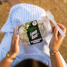 Load image into Gallery viewer, Person holding a 'Lunch Rush+' salad container with a fork outdoors.