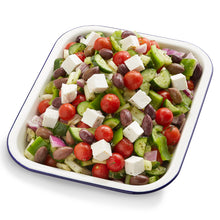 Load image into Gallery viewer, A serving of Greek Salad with tomatoes, cucumbers, bell peppers, olives, and feta cheese, dressed with garlic French dressing in a white dish with blue trim.