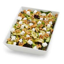Load image into Gallery viewer, A prepared pesto chicken and avocado salad with leafy greens, garnished with feta cheese and walnuts, served in a white rectangular dish.