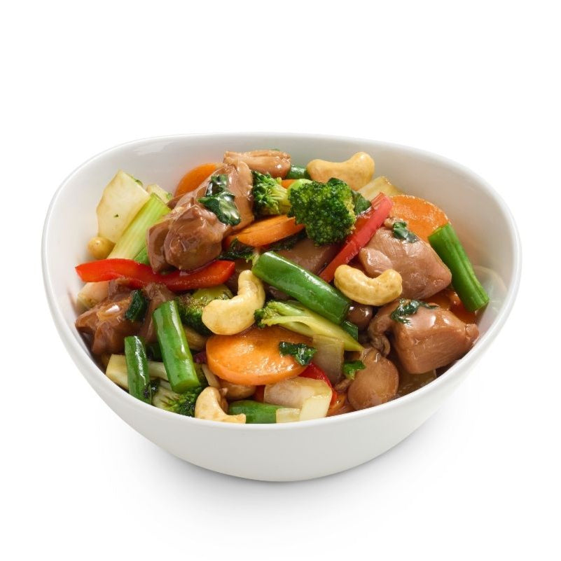 Bowl of chicken stir-fry with vegetables and cashews on a white background