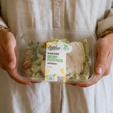 Load image into Gallery viewer, Person holding a Salad Servers Creamy Pesto Pasta with Chicken protein salad.
