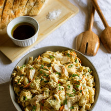 Load image into Gallery viewer, Grey bowl with pasta salad on a white tablecloth with bread and oil
