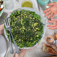 Load image into Gallery viewer, Green Goddess salad in a bowl on a table with people around
