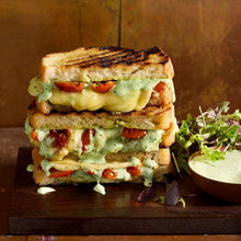 Load image into Gallery viewer, Stack of grilled vegetable sandwiches with a side of salad on a wooden board.
