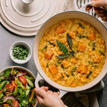 Load image into Gallery viewer, Creamy pumpkin and sage risotto served in a pot with fresh herbs and side salad.
