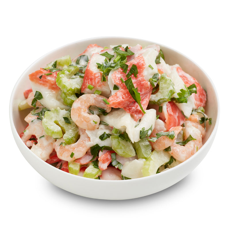 Seafood salad in a round white bowl with a white background