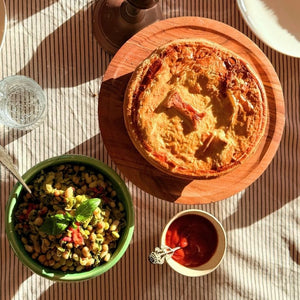 Dish of pie, salad, and tea on a wooden table