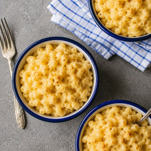 Load image into Gallery viewer, Bowls of creamy baked mac and cheese served on a grey table with cutlery and napkin.
