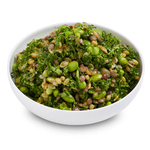 Load image into Gallery viewer, A bowl of edamame, freekeh, and kale salad with dressing.
